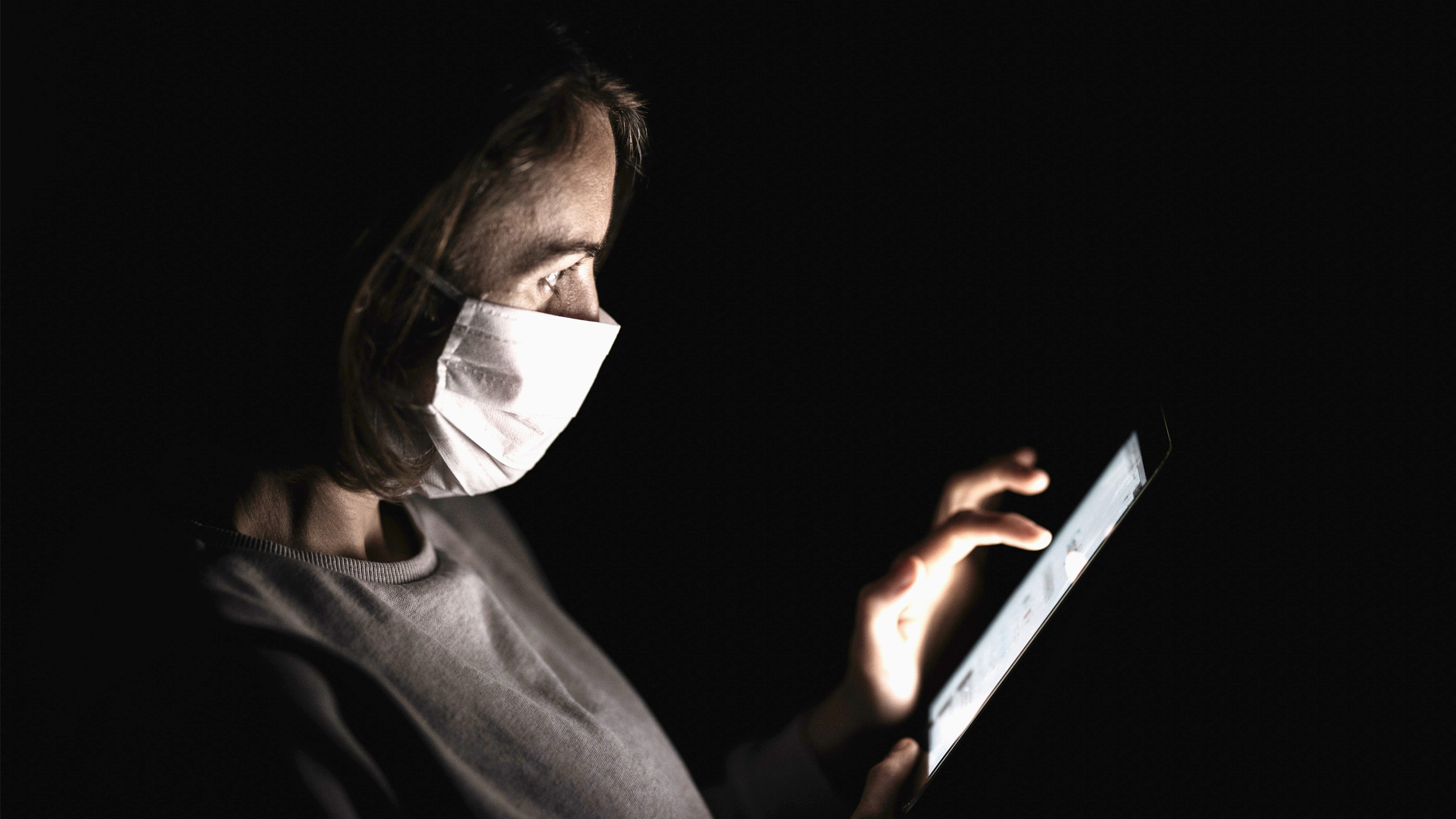 Woman wearing a face mask browsing the internet