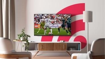 Freely themed living room with TV showing football