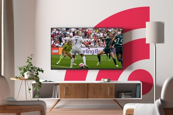 Freely themed living room with TV showing football