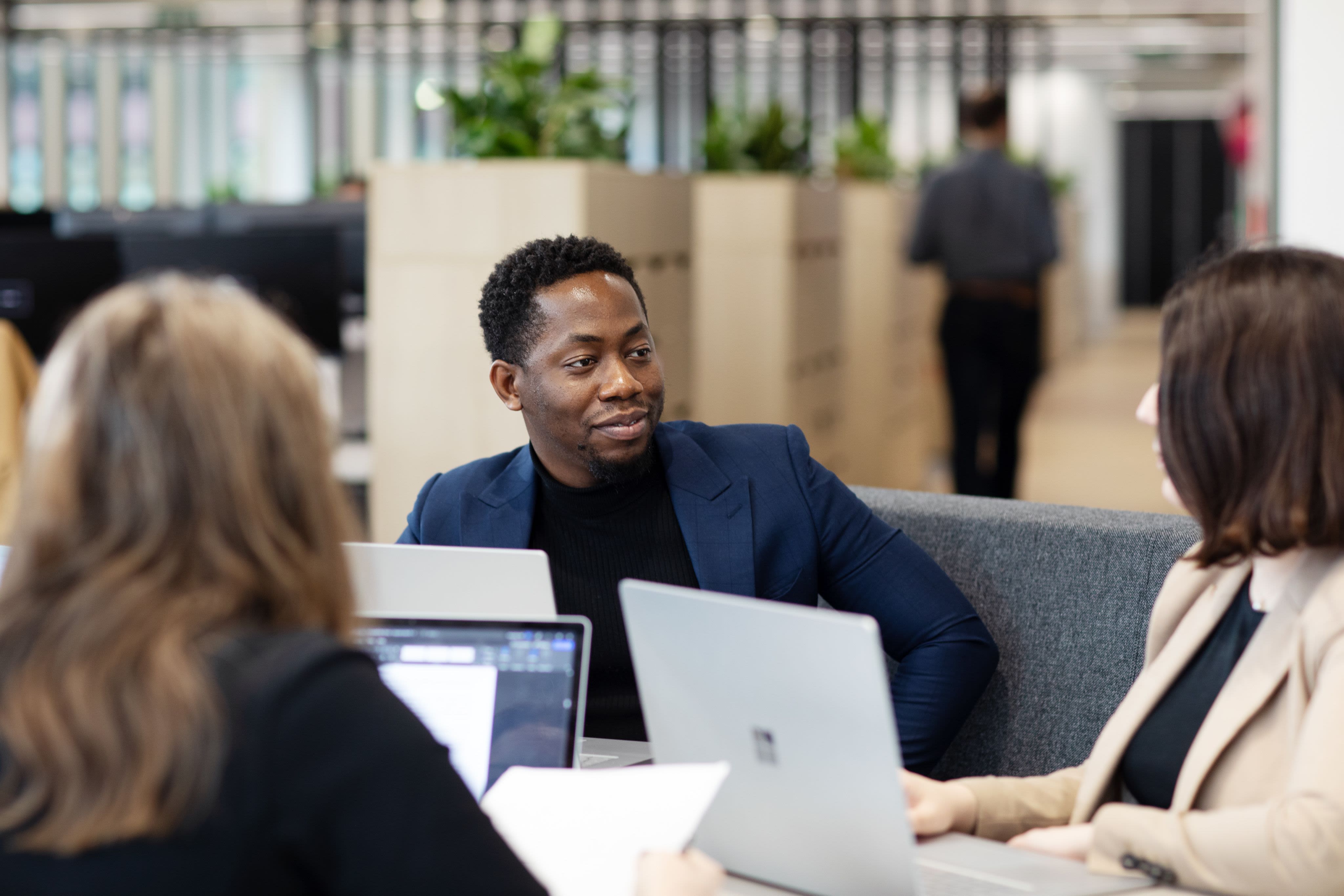 Woman and man in conversation in front of desktop computer monitor